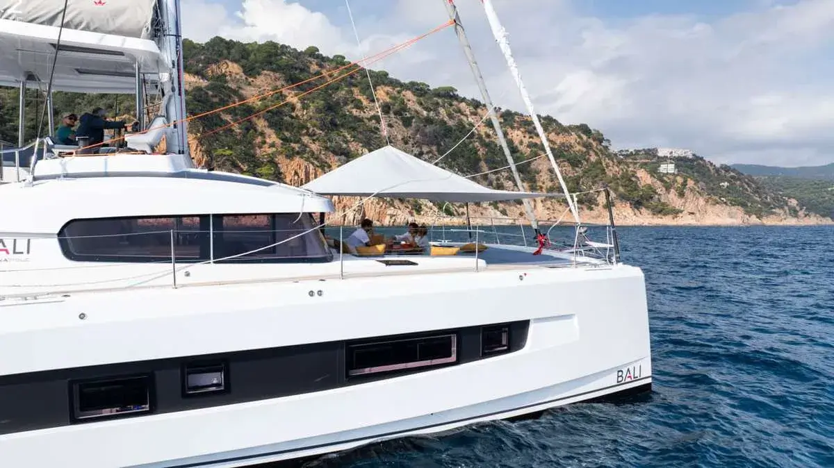 Guests on the shaded flybridge of a crewed catamaran